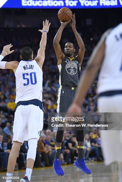 Kevin Durant of the Golden State Warriors shoots over Salah Mejri of the Dallas Mavericks during an NBA basketball game at ORACLE Arena on February...