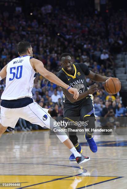 Draymond Green of the Golden State Warriors drives towards the basket and gets fouled by Salah Mejri of the Dallas Mavericks during an NBA basketball...