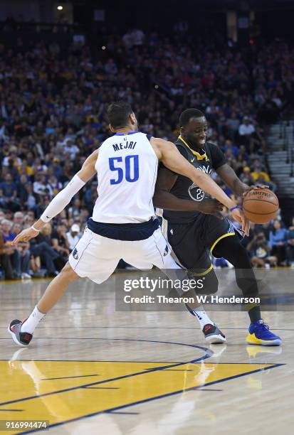 Draymond Green of the Golden State Warriors drives towards the basket and gets fouled by Salah Mejri of the Dallas Mavericks during an NBA basketball...