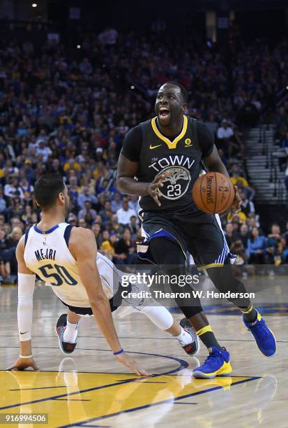 Draymond Green of the Golden State Warriors drives towards the basket and gets fouled by Salah Mejri of the Dallas Mavericks during an NBA basketball...