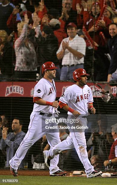 Maicer Izturis and Mike Napoli of the Los Angeles Angels of Anaheim score on a triple hit by Erick Aybar in the seventh inning against the Boston Red...