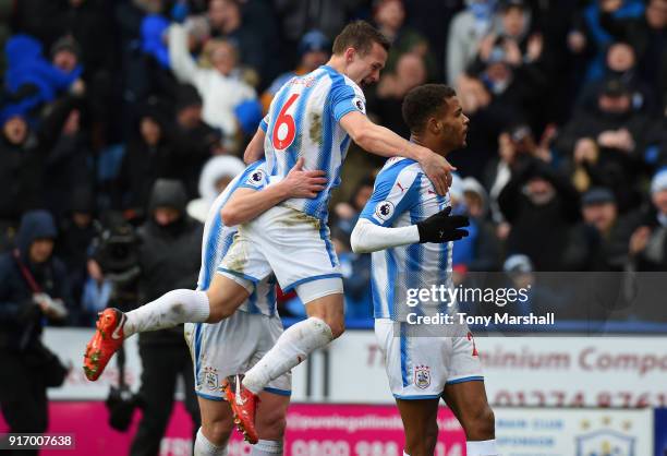 Steve Mounie of Huddersfield Town celebrates scoring their third goal with team mates Jonathan Hogg and Aaron Mooy during the Premier League match...