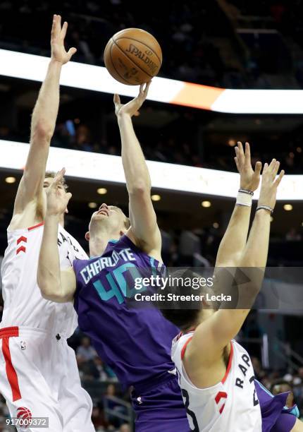 Cody Zeller of the Charlotte Hornets drives to the basket against Jakob Poeltl of the Toronto Raptors during their game at Spectrum Center on...