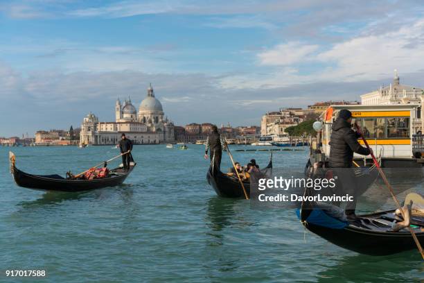 morning on venice bay with gondolas and tourists and  santa maria della sallute in background, italy - santa maria della salute celebrations in venice stock pictures, royalty-free photos & images
