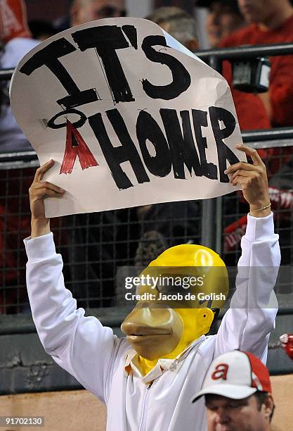 Fan of the Los Angeles Angels of Anaheim dressed as "Homer Simpson" hold a sign in support of the Angels during Game Two of the ALDS against the...