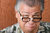 Older man with taped glasses making a funny face