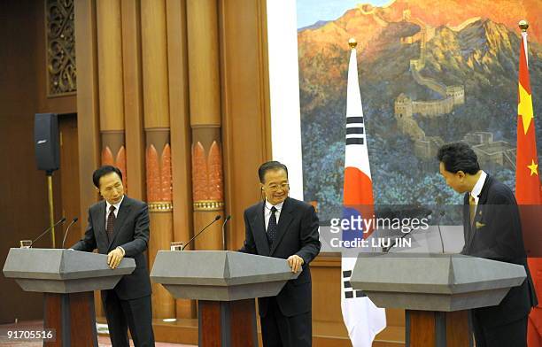 Chinese Premier Wen Jiabao and South Korean President Lee Myung-Bak greet new Japanese Prime Minister Yukio Hatoyama during a joint press conference...