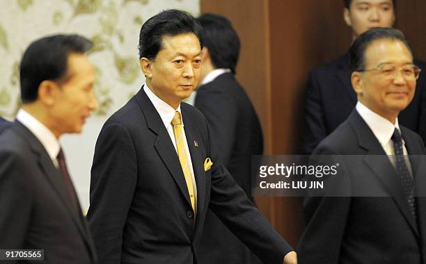 New Japanese Prime Minister Yukio Hatoyama walks with Chinese Premier Wen Jiabao and South Korean President Lee Myung-Bak as they arrive for a press...