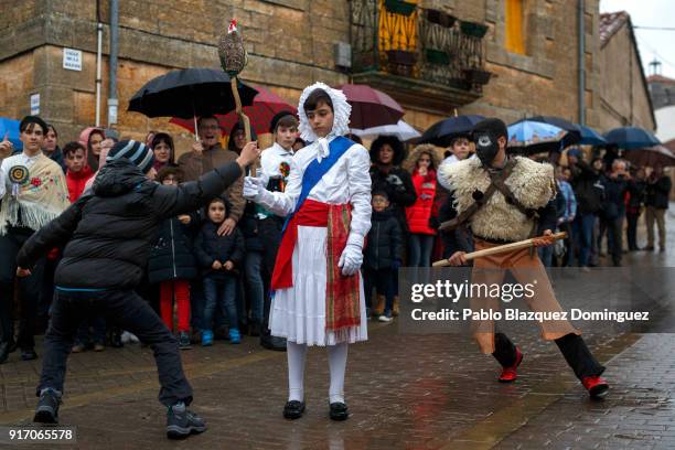 Boy takes a rag rooster from 'El Rey' as a 'Zarramaco' chases him during 'El Gallo de Carnaval' of Mecerreyes on February 11, 2018 in Mecerreyes, in...