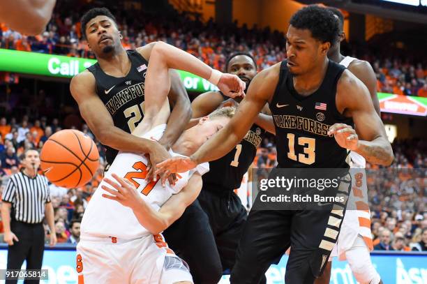 Terrence Thompson of the Wake Forest Demon Deacons, Marek Dolezaj of the Syracuse Orange and Bryant Crawford of the Wake Forest Demon Deacons react...