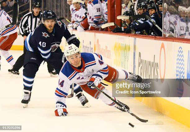 New York Rangers Defenceman Neal Pionk is tripped up by Winnipeg Jets Right Wing Joel Armia during a NHL game between the Winnipeg Jets and New York...