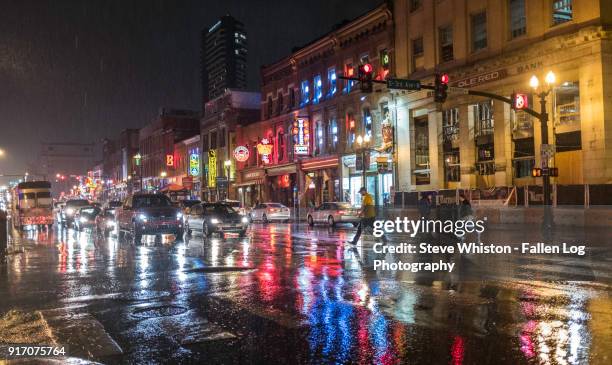 rain in the city - man crossing the road in nashville honky tonk district in the rain - nashville disco party ストックフォトと画像