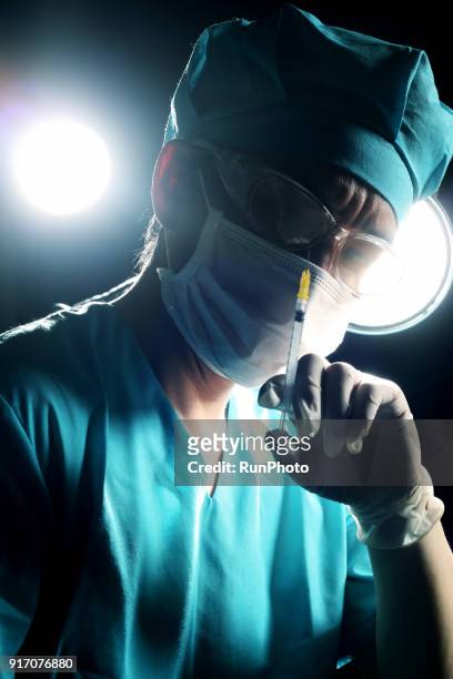 close-up of surgeon holding syringe - surgical loupes stock pictures, royalty-free photos & images