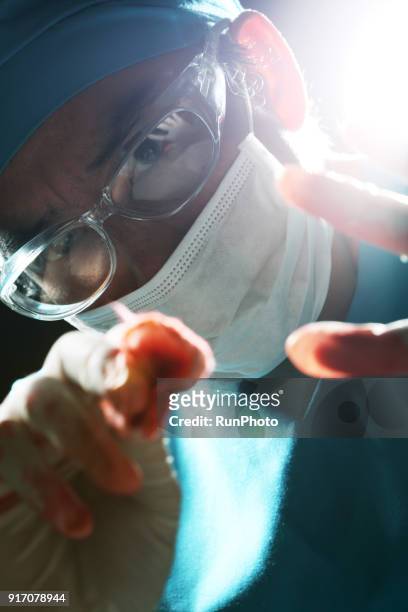 surgeon  wearing surgical gloves holding gauze swab - surgical loupes stock pictures, royalty-free photos & images