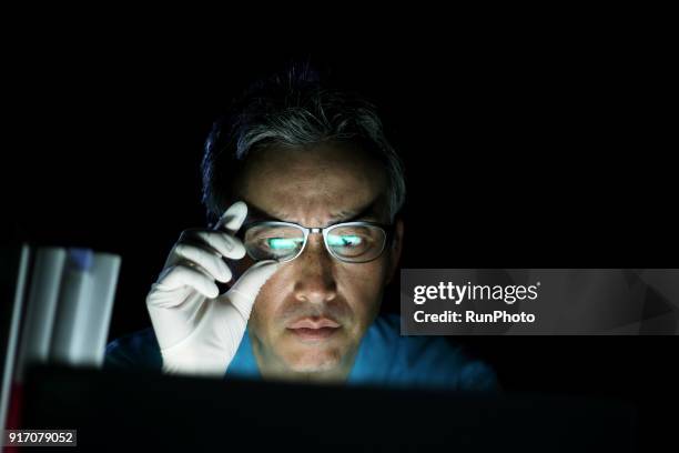 doctor using laptop in office - working overtime - fotografias e filmes do acervo