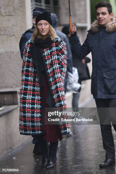 Guest wears a beanie hat, a wool colored coat, under the rain, outside Paul Smith, during Paris Fashion Week - Menswear Fall Winter 2018-2019, on...