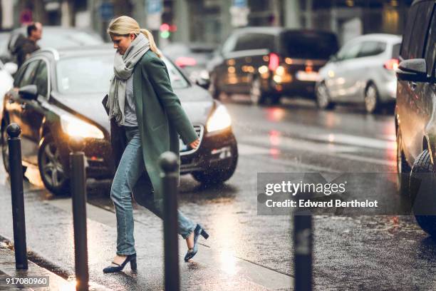 Guest wears a scarf, a coat, jeans, shoes, under the rain, outside Paul Smith, during Paris Fashion Week - Menswear Fall Winter 2018-2019, on January...