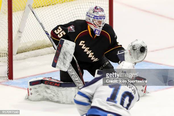 Cleveland Monsters goalie Matiss Kivlenieks makes a glove save to shot the shot of Manitoba Moose right wing Buddy Robinson during the third period...