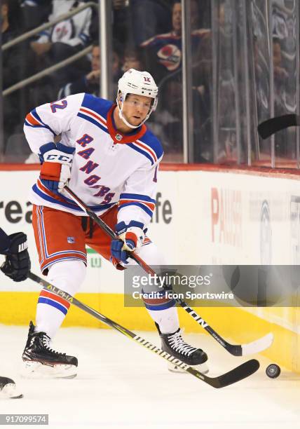 New York Rangers Center Peter Holland chips the puck up the boards during a NHL game between the Winnipeg Jets and New York Rangers on February 11,...