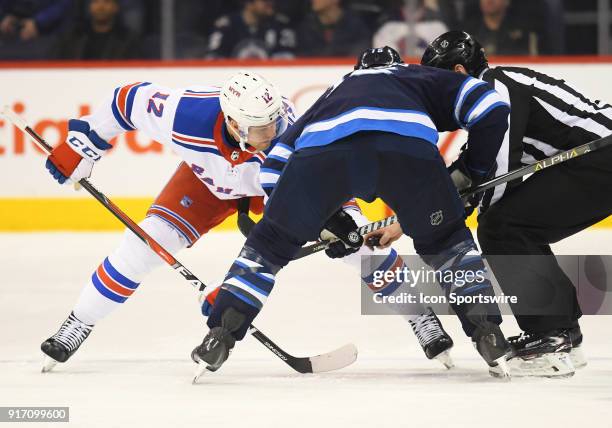 New York Rangers Center Peter Holland and Winnipeg Jets Center Matt Hendricks face off during a NHL game between the Winnipeg Jets and New York...