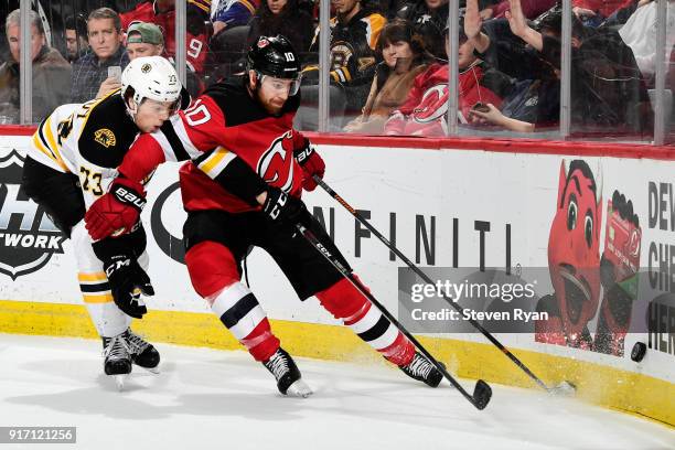 Jimmy Hayes of the New Jersey Devils is pursued by Charlie McAvoy of the Boston Bruins during the second period at Prudential Center on February 11,...