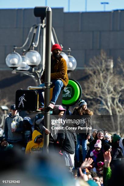 Eagles fans sit on a corner pole during festivities on February 8, 2018 in Philadelphia, Pennsylvania. The city celebrated the Philadelphia Eagles'...