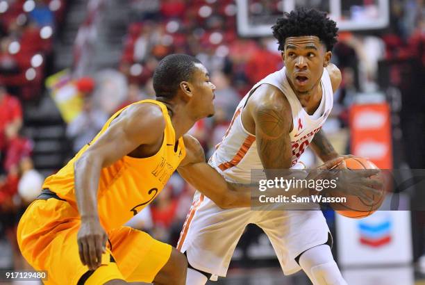 Jovan Mooring of the UNLV Rebels looks to drive against Louis Adams of the Wyoming Cowboys during their game at the Thomas & Mack Center on February...