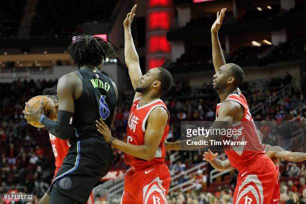 Johnathan Motley of the Dallas Mavericks controls the ball defended by Markel Brown of the Houston Rockets and Luc Mbah a Moute in the second half at...