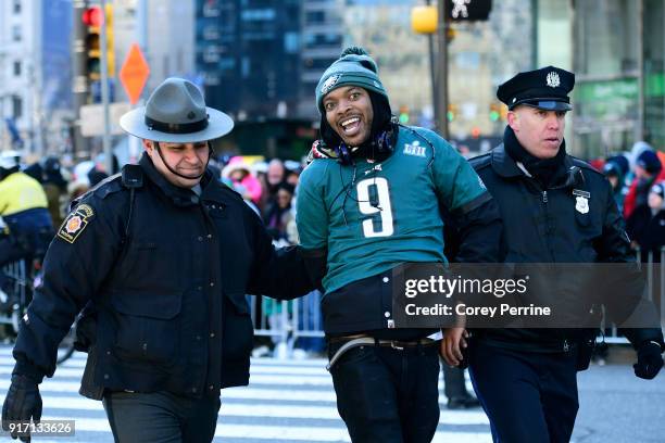An Eagles fan is cuffed after climbing a convenience/newsstand during festivities on February 8, 2018 in Philadelphia, Pennsylvania. The city...