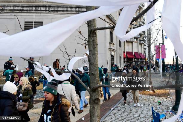 Eagles fans walk downtown after the parade concludes, passing toilet paper-laden trees, during festivities on February 8, 2018 in Philadelphia,...