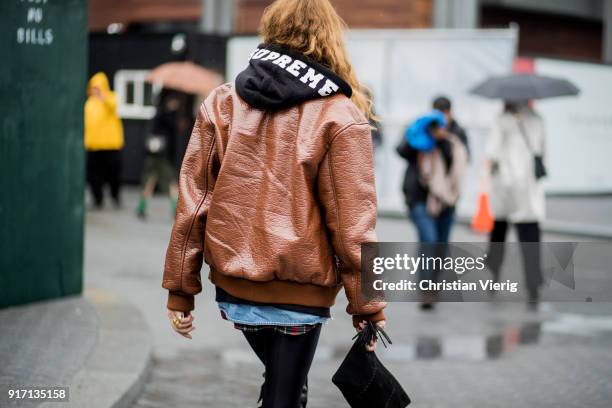 Ece Sukan wearing Supreme hoodie, brown leather jacket, plaid button shirt, black overknees with fringes seen outside Tibi on February 11, 2018 in...