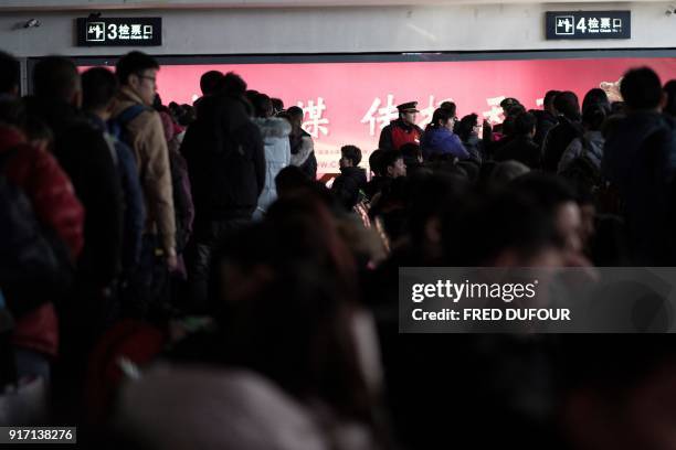 This photo taken on February 10, 2018 shows travellers lining up to take their trains at the West Railway Station in Beijing, as people depart the...