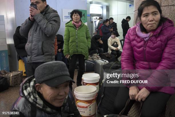 This photo taken on February 10, 2018 shows people waiting for train tickets at the West Railway Station in Beijing as travellers depart the capital...