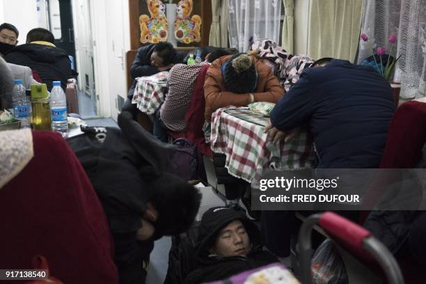 This photo taken on February 10, 2018 shows people sleeping in the restaurant car during the 26-hour train journey from Beijing to Chengdu, in...