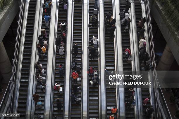 This photo taken on February 10, 2018 shows travellers rushing to the waiting rooms before boarding trains at the West Railway Station in Beijing, as...