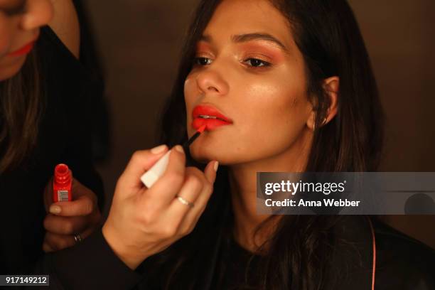 Model Cris Urena prepares backstage with Maybelline New York at the Nomo Soho Hotel on February 11, 2018 in New York City.