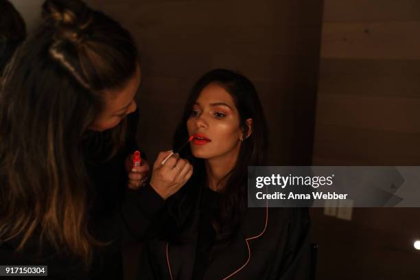 Model Cris Urena prepares backstage with Maybelline New York at the Nomo Soho Hotel on February 11, 2018 in New York City.