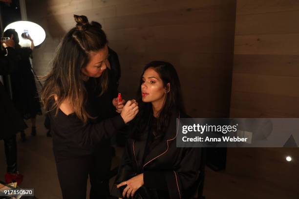 Model Cris Urena prepares backstage with Maybelline New York at the Nomo Soho Hotel on February 11, 2018 in New York City.