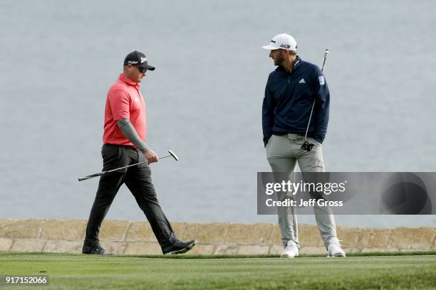 Ted Potter Jr. And Dustin Johnson walk across the 18th green during the Final Round of the AT&T Pebble Beach Pro-Am at Pebble Beach Golf Links on...