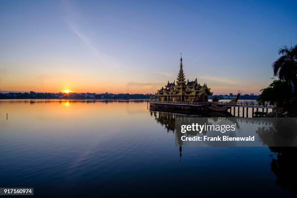The Pyi Gyi Mon Royal Barge, a swimming restaurant, is floating on Kandawgyi Lake at sunrise.