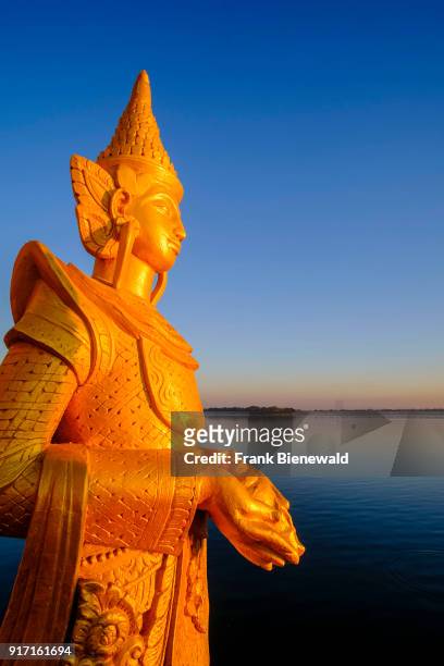 Golden statues are decorating the Pyi Gyi Mon Royal Barge, a floating restaurant, floating on Kandawgyi Lake at sunrise.