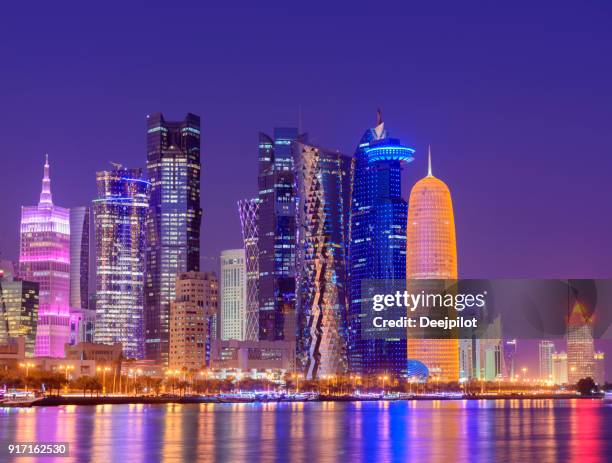 the downtown doha city skyline illuminated at sunset, qatar - corniche stock pictures, royalty-free photos & images