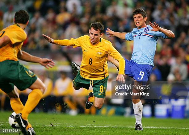 Luke Wilkshire of the Socceroos is brought down by Klaas Jan Huntelaar of the Netherlands during the International friendly football match between...