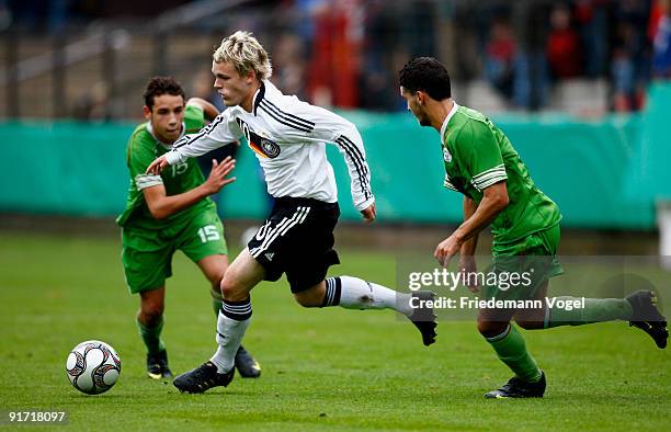 Christopher Buchtmann of Germany and Julien Lopez and Med-Nadhir Ziane of Algeria challenge for the ball during the U18 International Friendly match...