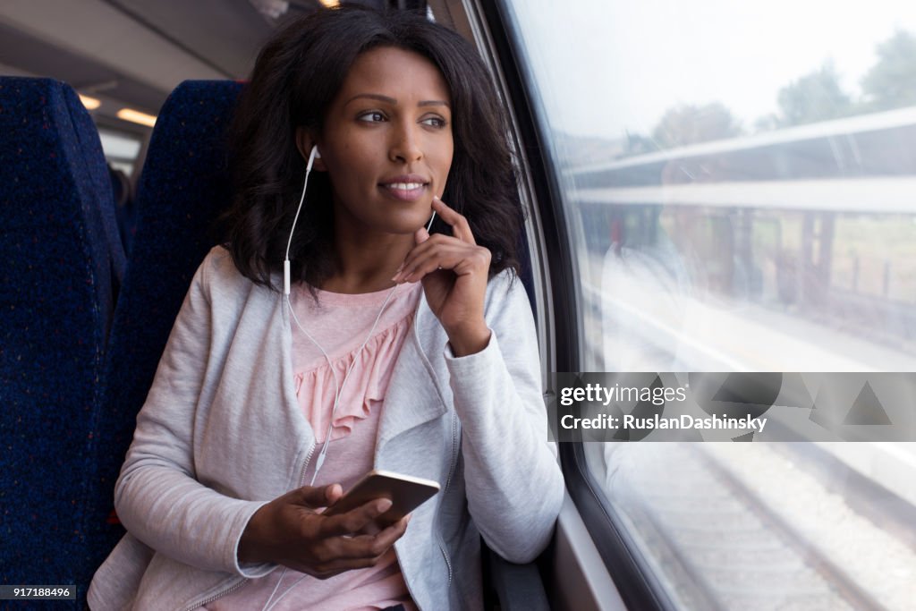 Femme écoutant de la musique dans le train.