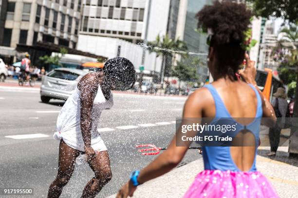 young friends having carnival party at the street - rio de janeiro celebrates during carnival season stock pictures, royalty-free photos & images