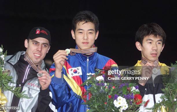 Gold medalist Ryoung Min of Korea , silver medalist Eric Bedard of Canada and Bronze medalist Jiajun Li of China pose 12 March 2000, on the podium of...
