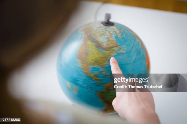 Berlin, Germany A woman taps her finger on a spinning globe on February 08, 2018 in Berlin, Germany.