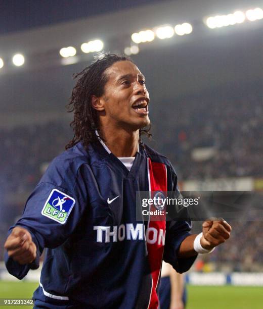 Le milieu de terrain brésilien du PSG Ronaldinho, auteur des premiers buts pour son équipe, salue les supporteurs parisiens, le 26 octobre 2002 au...