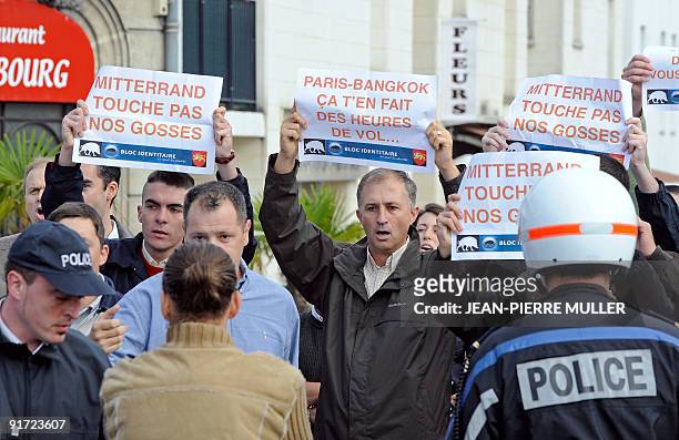 Far-right supporters hold banners reading "Mitterrand, Don't Touch Our Kids" and "Paris-Bangkok, It makes your flight long" , during a demonstration...